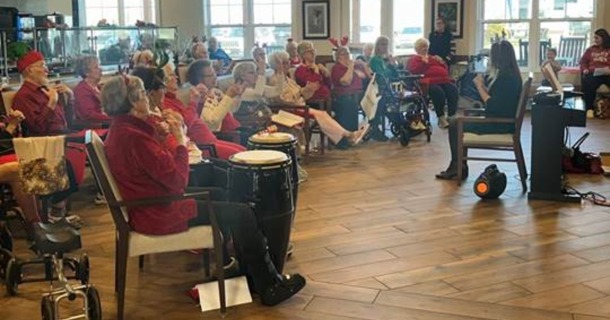 Christine Hollister, Tabitha at Prairie Commons Life Enrichment Events Coordinator, directs a performance during the “Santa’s Singalong Spectacular” event.